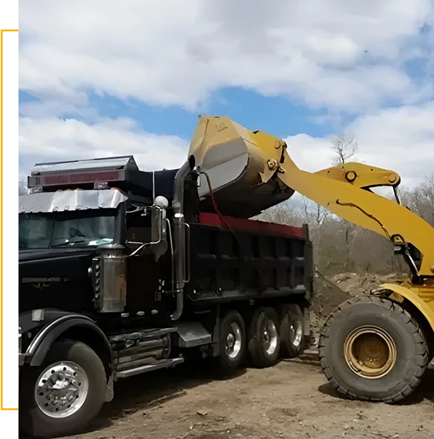 A large dump truck with a big yellow tractor on it's back.