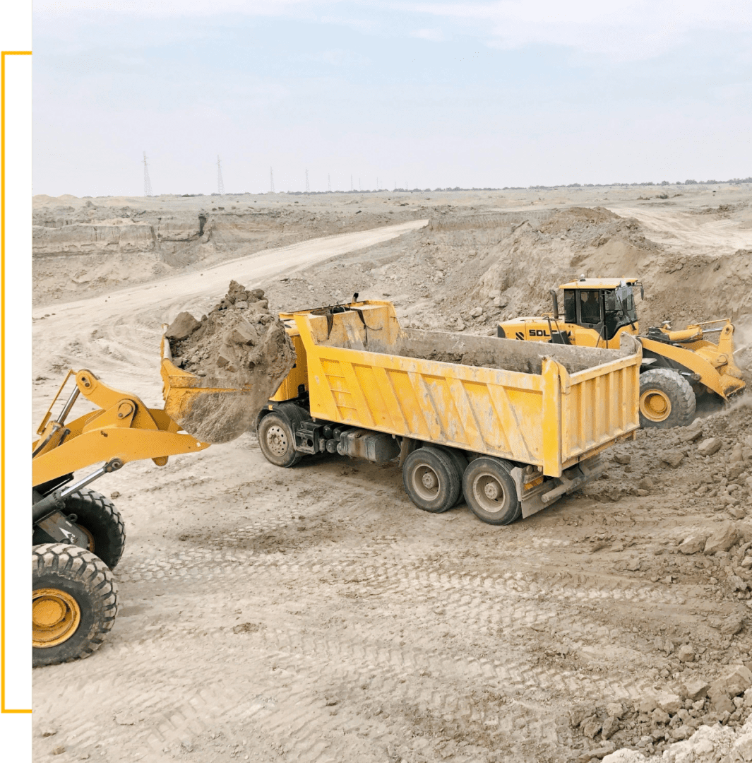 A yellow dump truck and a yellow tractor in the dirt.