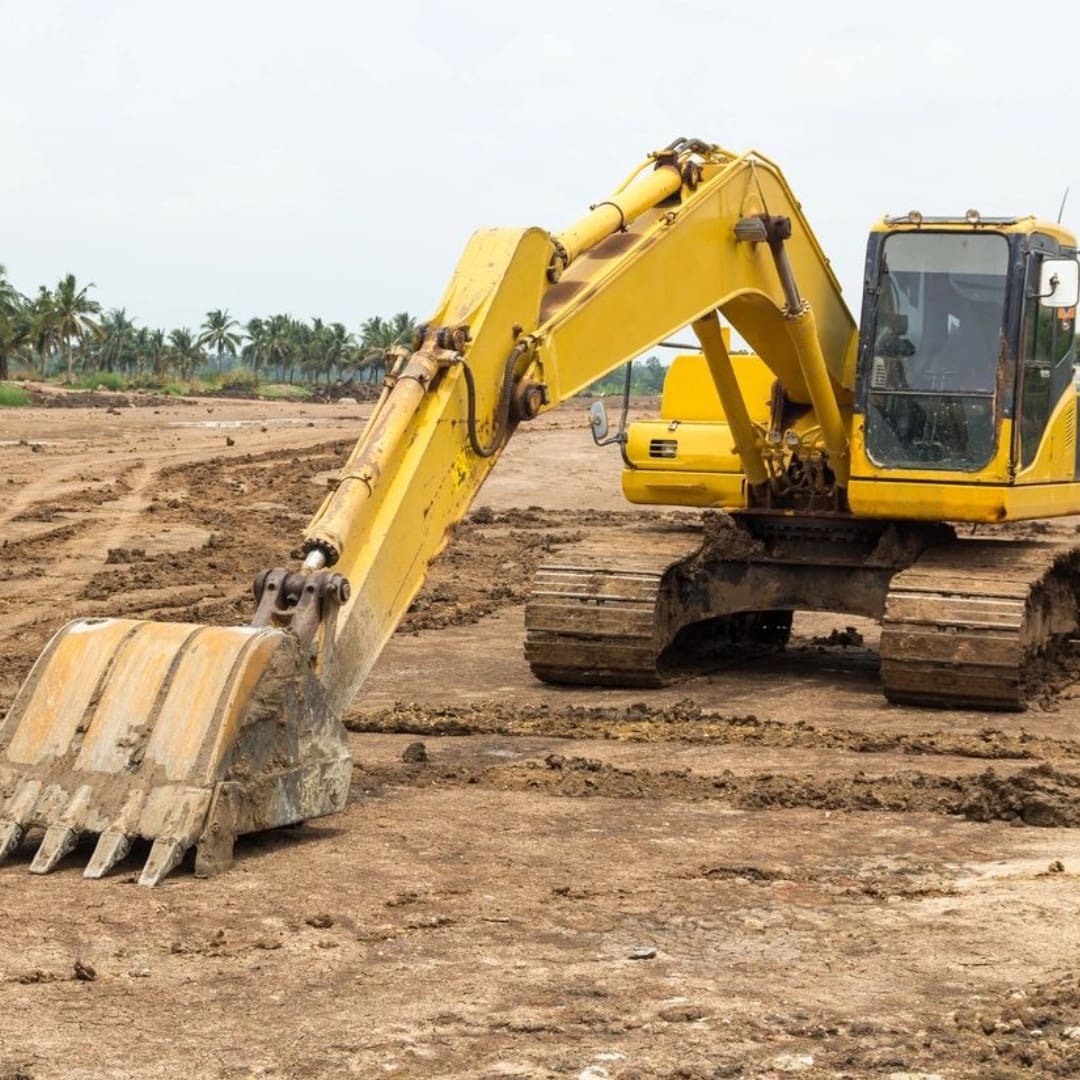 A yellow and black tractor is on the dirt